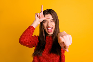 Photo of cheerful rude ridiculous girlfriend pointing at you showing lose sign screaming laughind...
