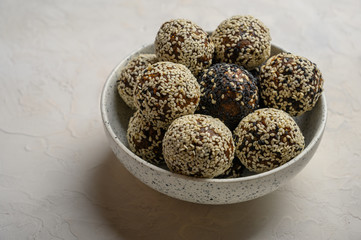 Homemade energy balls in a light vase on a white background