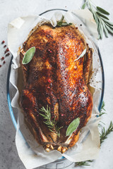 Christmas baked duck with herbs and spices in the oven dish, top view