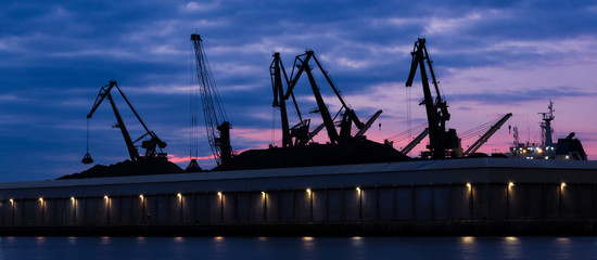TRANSSHIPMENT TERMINAL - Port cranes on the coal quay in Gdynia at sunrise