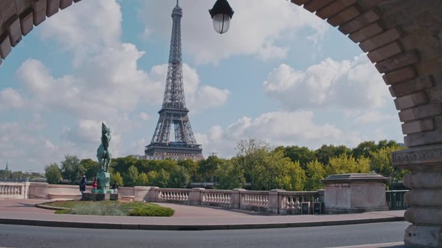 4K Eiffel Tower and statue La France renaissante on Pont de Bir-Hakeim, view from an arch during daytime, Paris, France - Slow Motion