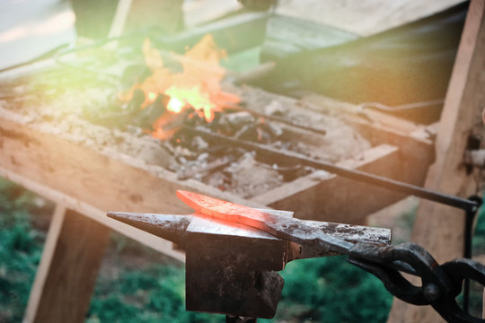 Hot knife blade on the anvil. Workpiece in the forge on the background of the fire. The heat from the stove and the blade of the forged sword.
