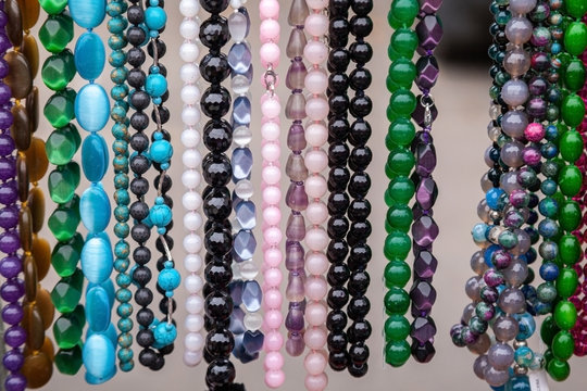 Various colorful beads in the market. Wallpaper background of a colorful necklace made of precious stones and colored beads.