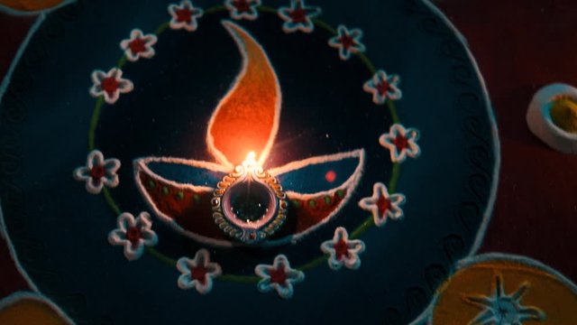 celebration of Indian festival Diwali - oil lamps lit on colorful rangoli