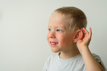 Little boy with hearing gesture