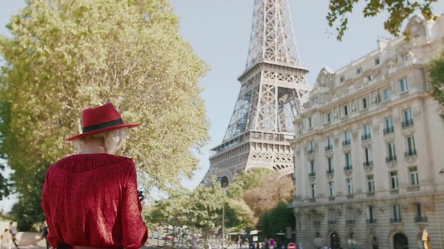 Young fashionable traveller, tourist girl takes photo of street with Eiffel tower in Paris