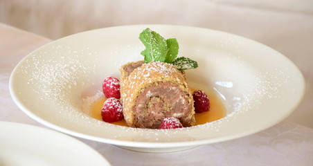 Biskuitroulade - Biskuitrolle - Nachspeise Dessert am Buffet mit Himbeeren und Mangosauce