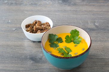 Cream of pumpkin soup with pumpkin seeds, parsley and dry bread