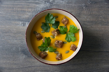 Cream of pumpkin soup with pumpkin seeds, parsley and dry bread
