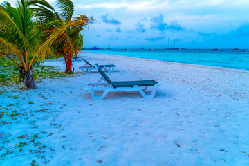 Naklejka na ściany i meble Lounge chairs on a beautiful tropical beach at Maldives
