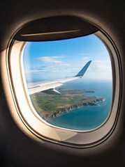 looking out of aircraft window over coastal cliffs on the east coast of Ireland