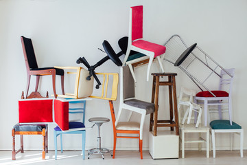 many multicolored chairs stand in the white room