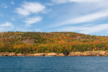 Fototapeta na wymiar View of fall foliage on the hills of Acadia National Park as seen from Frenchman Bay