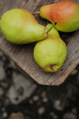 green pears on wood table and a dark background