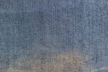 Texture of the inner side of a blue denim fabric with the big yellow stain 