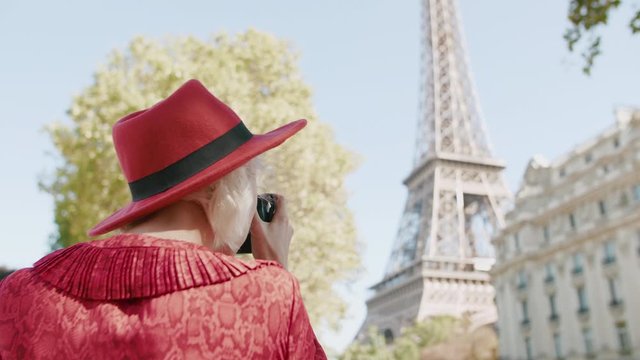 Young happy smiling fashionable traveller, tourist girl takes photo of street with Eiffel tower in Paris