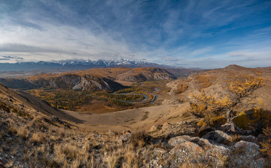 Winding river on a background of mountains and autumn trees