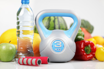 Fitness concept – healthy nutrition and equipment for fitness exercises on the white background. 