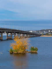 Autumn river landscape - View of the Saratov bridge and the Volga river, a small island in the foreground