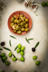 plate of seasoned olives on a white background,decorated with olives and fresh leaves,healthy food