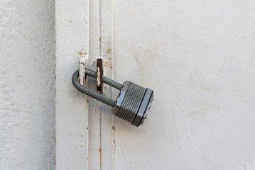 silver padlock close a metallic dorr painted white