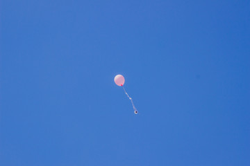 Blue sky with a pink flying ball.