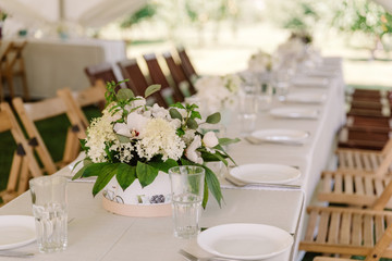 Serving tables for guests at the wedding stylish dishes and cutlery.