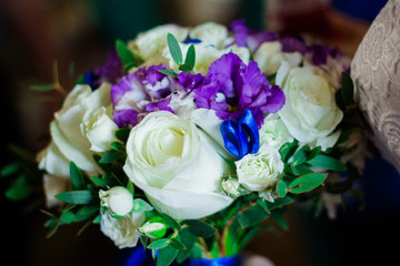 Wedding bridal bouquet. White roses and purple carnations.