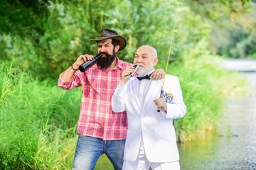 lets drink. mature man fisher celebrate retirement. retired businessman. male friendship. hobby and sport activity. two fishermen with fishing rods. summer family weekend. father and son fishing