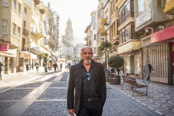 Mature man walking in street with suit in european city