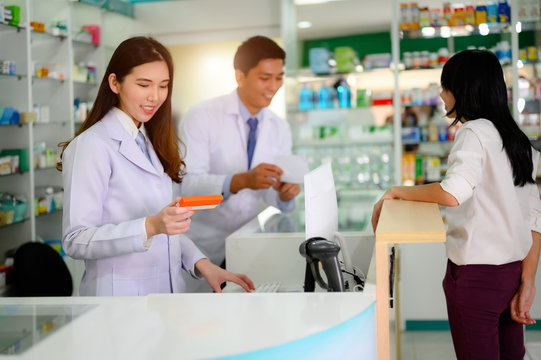 hand of woman pharmacist holding box or caase of medicine container, estimation cost of the pills in charge, with costomer and consultant