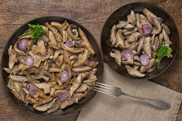 Delicious fried mushrooms in pan on table
