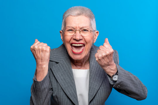 Excited old business lady celebrating some incredible news