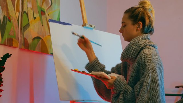 Young woman artist paint canvas with oil at beauty loft studio room