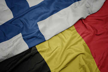waving colorful flag of belgium and national flag of finland.