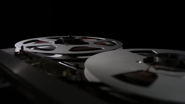  Retro Analog Quarter Inch Tape Recorder Being Operated in a Darkened Room