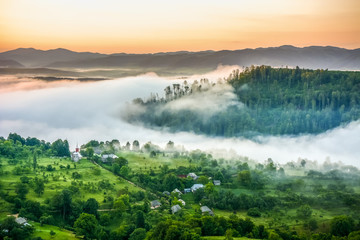 Beautiful scenery landscape sunrise foggy morning village Maramures Romania 