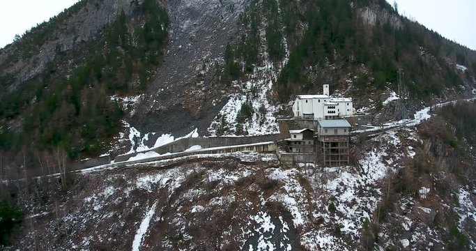 Aerial drone footage little lonely church on steep hillside in italian alps in winter. 