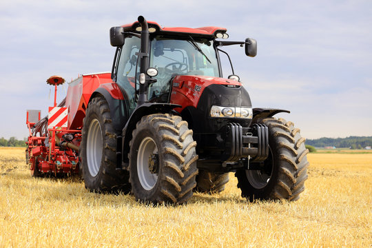 Red Case IH Tractor and Seeder on Stubble Field. Illustrative Editorial content.