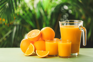 Glassware of fresh orange juice on table outdoors