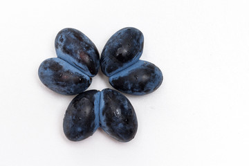 Ugly spoiled plum in the shape of a heart on a white background.