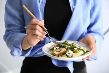Woman with plate of tasty salad, closeup