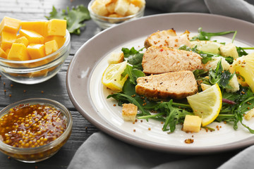 Plate with tasty salad on wooden background, closeup