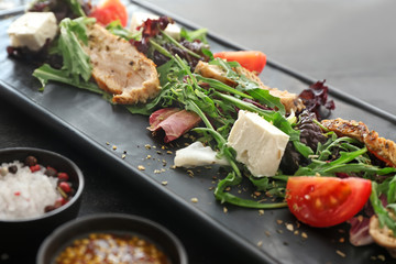 Plate with tasty salad on dark background, closeup