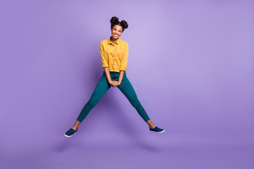 Fototapeta na wymiar Full length photo of pretty dark skin lady jumping high vacation time summer amazing mood wear casual yellow shirt trousers isolated purple color background