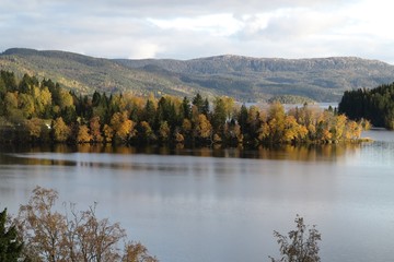 Autumn landscape of mountain and lake, with the colorful trees, symmetric reflection in the clean water
