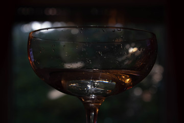 Glas mit Wasser und Tropfen bei wenig Belichtung