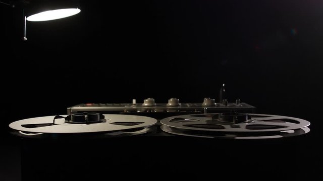  Retro Analog Quarter Inch Tape Recorder Being Operated in a Darkened Room
