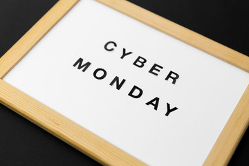 shopping, sale and outlet concept - white magnetic board with cyber monday words on black background