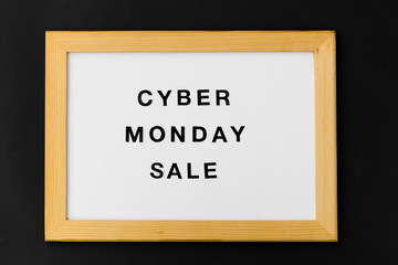 shopping and marketing concept - white magnetic board with cyber monday sale words on black background